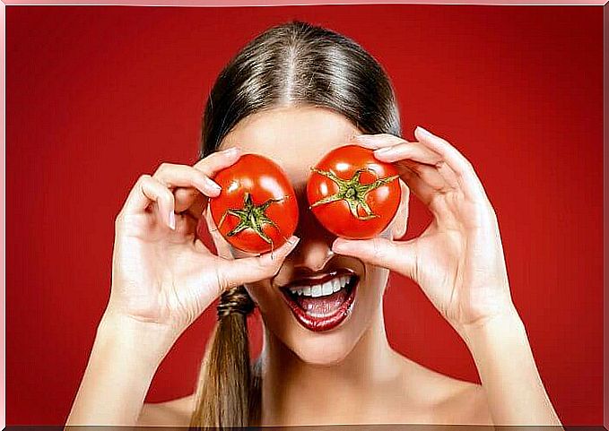 Woman with tomatoes in front of her eyes