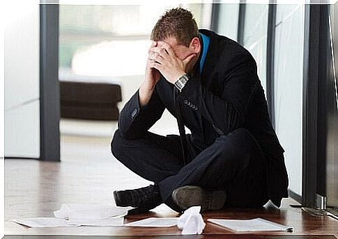 Man sitting with hands in front of his face