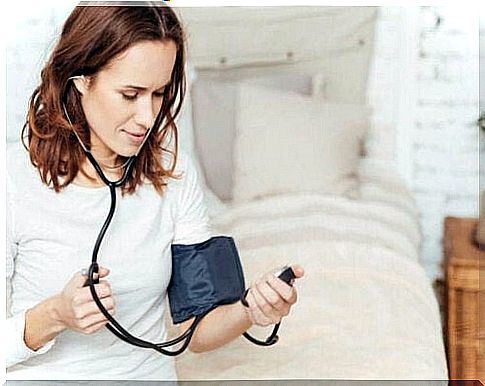 A woman measures her blood pressure