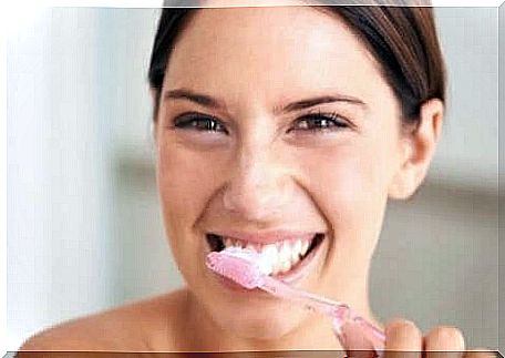 A woman brushes her teeth